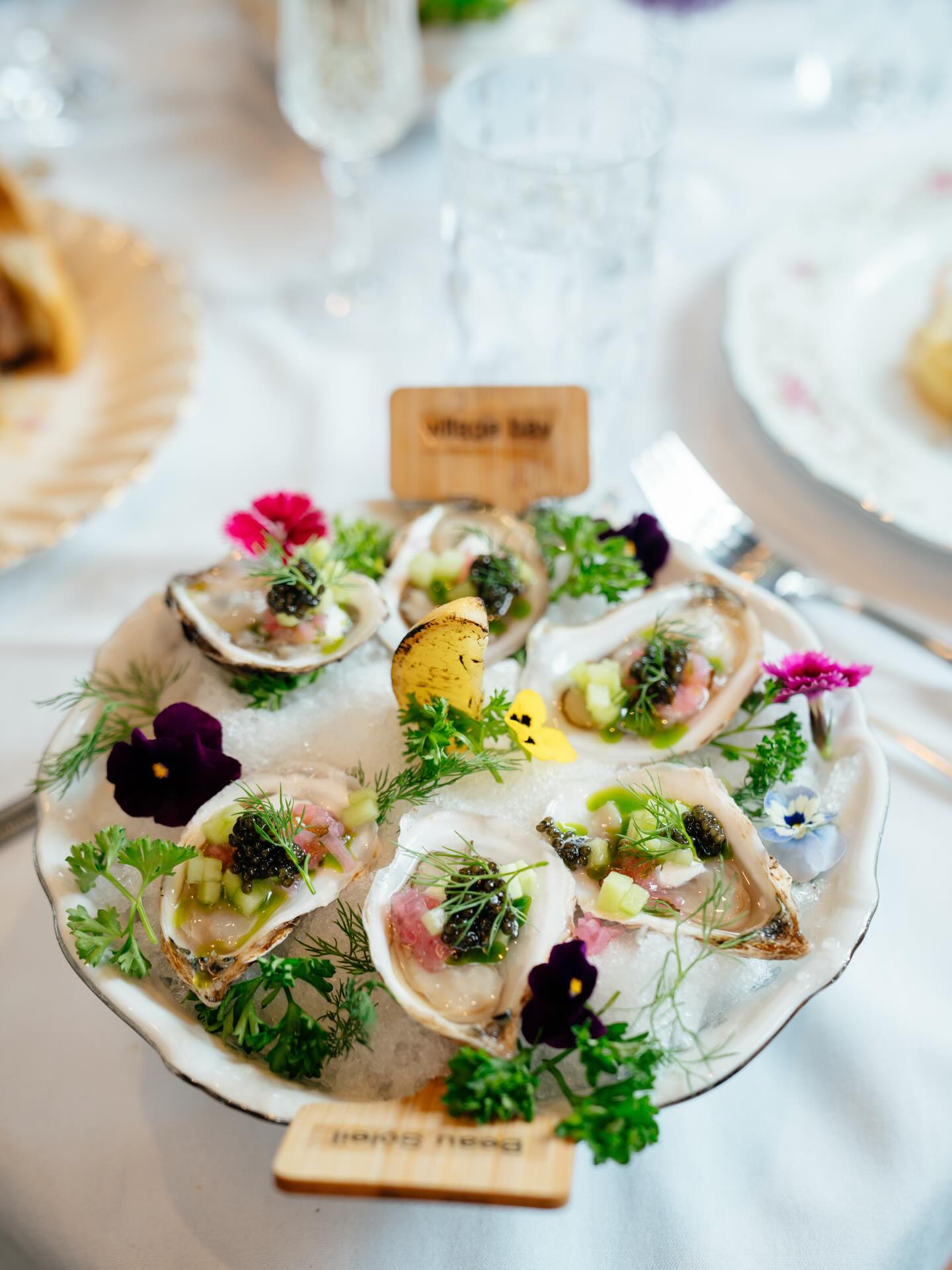 Oysters on the half shell dressed with caviar, herbs and pansies